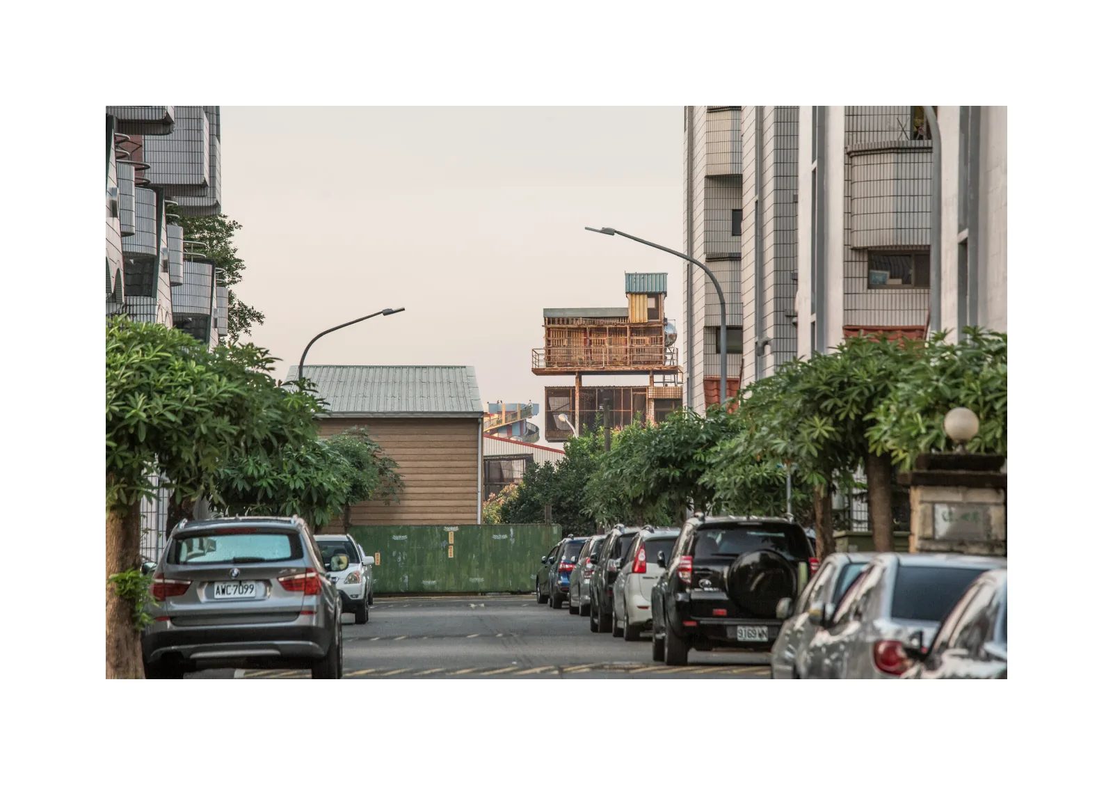 小冊子《1》第 11 頁：停滿汽車的住宅街道盡頭，露出屋頂上的鴿舍。